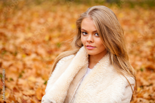 Close up portrait of young blonde beautiful woman in autumn park