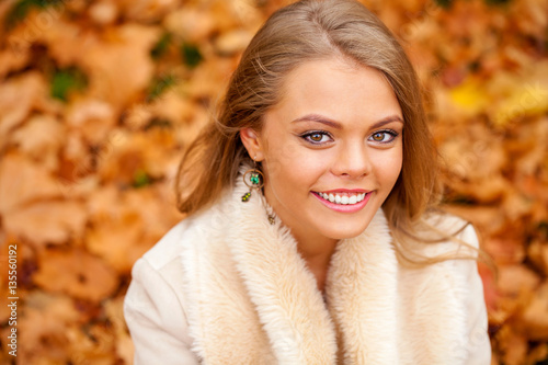 Close up portrait of young blonde beautiful woman in autumn park © Andrey_Arkusha