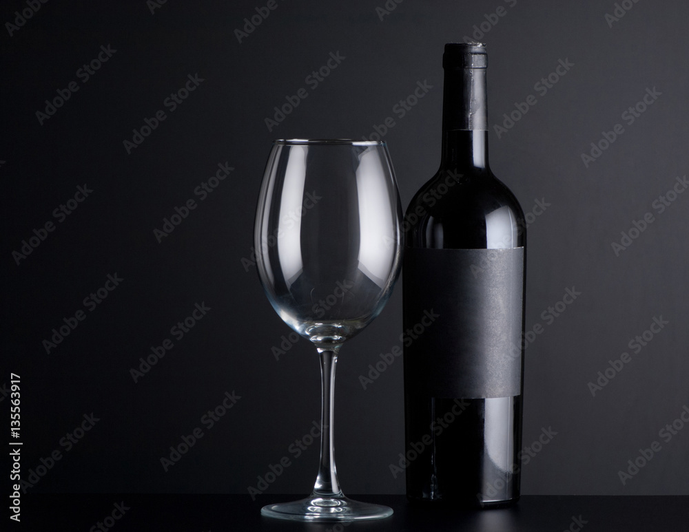 bottle red of wine with a glass on a black background bottle red of wine with a glass on a black background