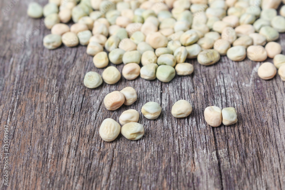 dry sugar pea seed, green nuts on the wood board background