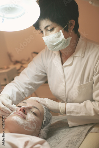 Woman with a facial mask in a spa center. photo