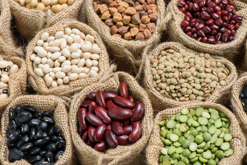 Obraz premium Multicolor dried legumes in small sack cloth, Top view shooting