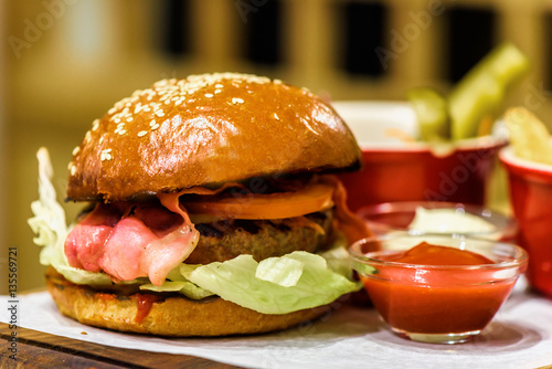 Homemade fresh burger with bacon on a wooden platter