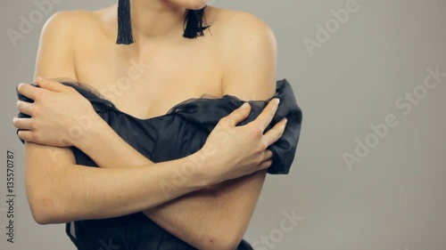 Gorgeous brunette woman bares her shoulders slowly