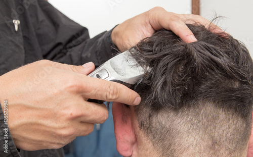 hairdresser cuts men's hair cut