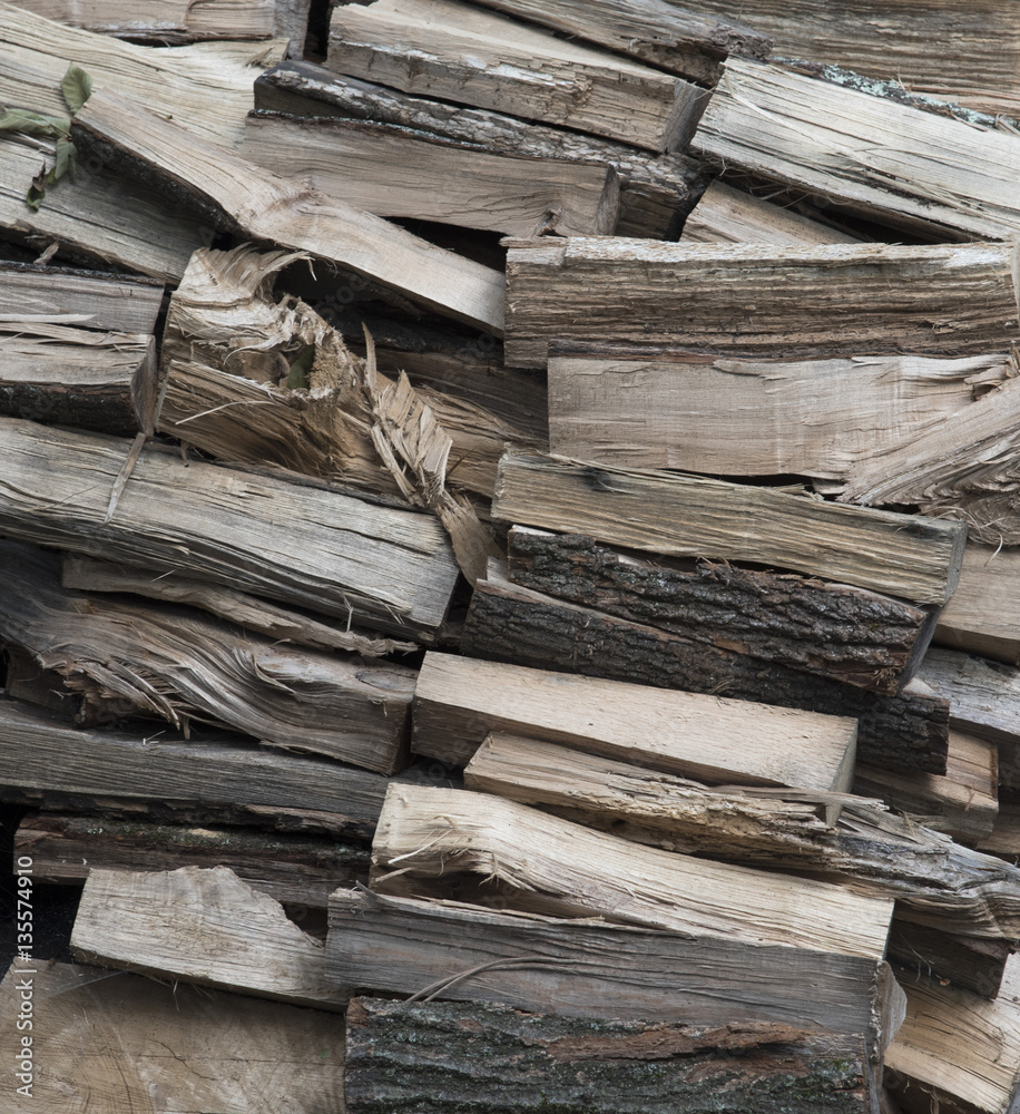 Stack of raw cut wood from light to dark brown waiting for a winter fireplace Stack of raw cut wood from light to dark brown waiting for a winter fireplace
