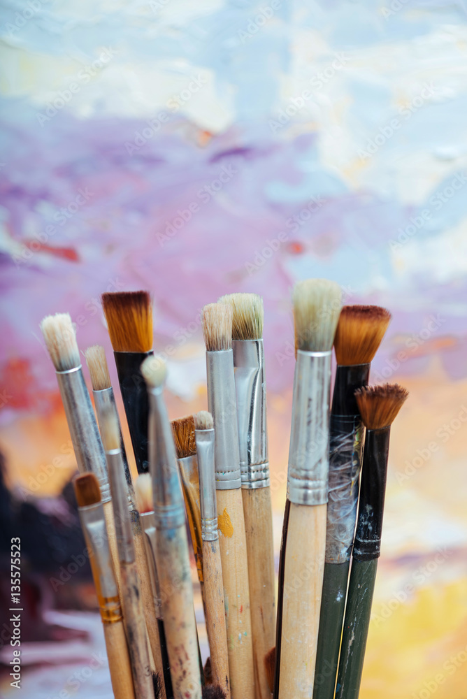 Fototapeta premium Close up of painting brushes on colorful background