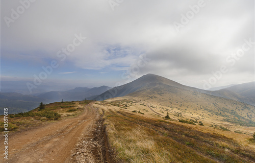 Trail in the mountains under cloudy sky. Carpathians