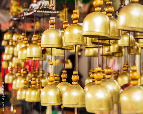 many brass bells hanging on the rope in the shop , selective focus bell