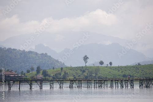 Wooden bridge across river with foggy background locanted at sanklaburee , Kanchanaburee province west of thailand