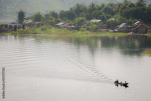 Wooden bridge across river with foggy background locanted at sanklaburee , Kanchanaburee province west of thailand photo