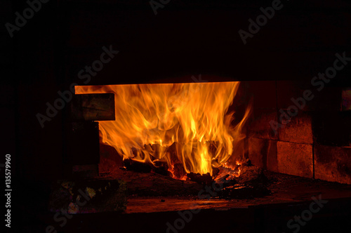 A coal forge in the blacksmith shop blazes