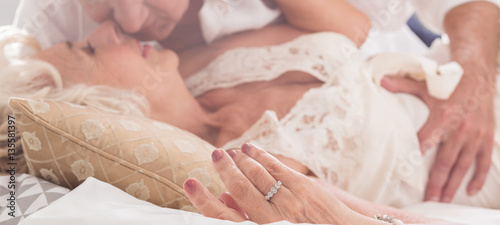Foto Elderly couple kissing in bed