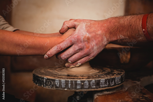 Hands working on pottery wheel