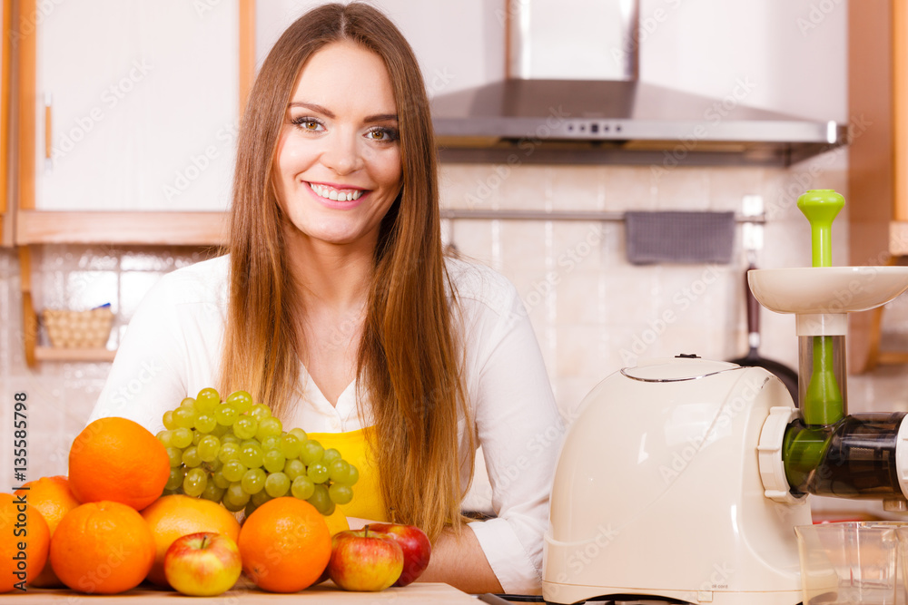 Woman in kitchen preparing fruits for juicing Woman in kitchen preparing fruits for juicing
