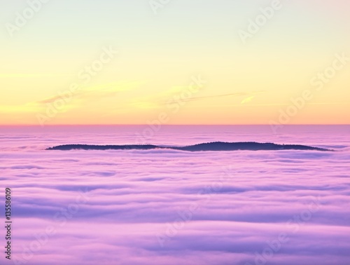 In winter mountains. Peaks of  mountains above creamy mist.