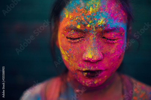 Woman's face covered with colorful paints for Holi Festival photo