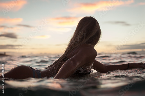 Female surfer in sea at sunset, Oahu, Hawaii, United States of America  photo