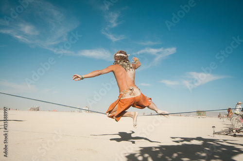 Man jumping from hot desert sand 