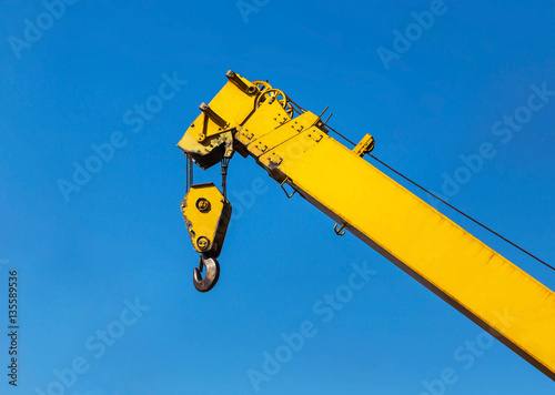 Big yellow construction crane on blue sky background