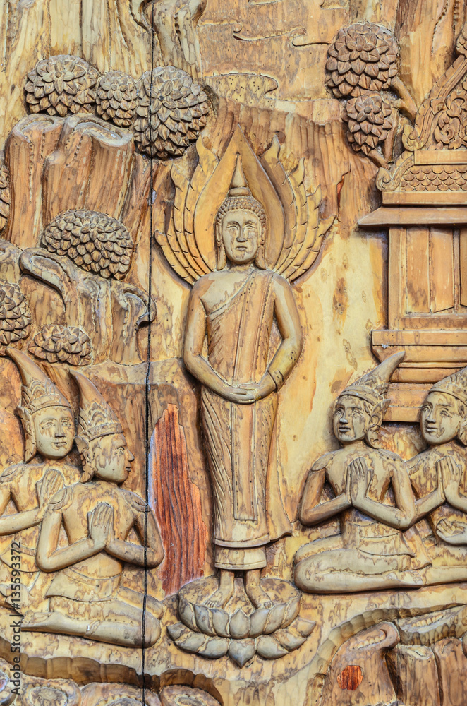 Buddha wooden carving on window in a temple, Thailand.