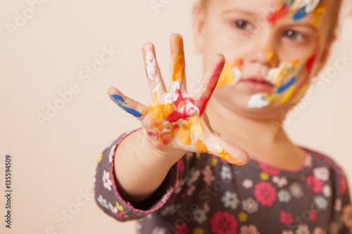 Happy cute little girl with colorful painted hands