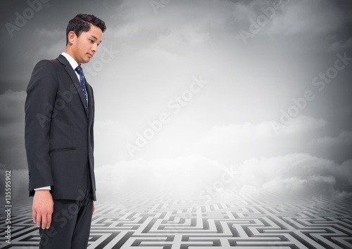 Composite image of businessman looking at a maze