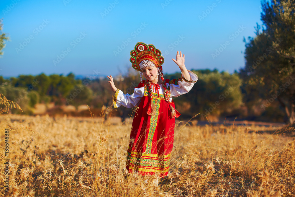 Beautiful girl in Russian folk costume dancing at field Beautiful girl in Russian folk costume dancing at field