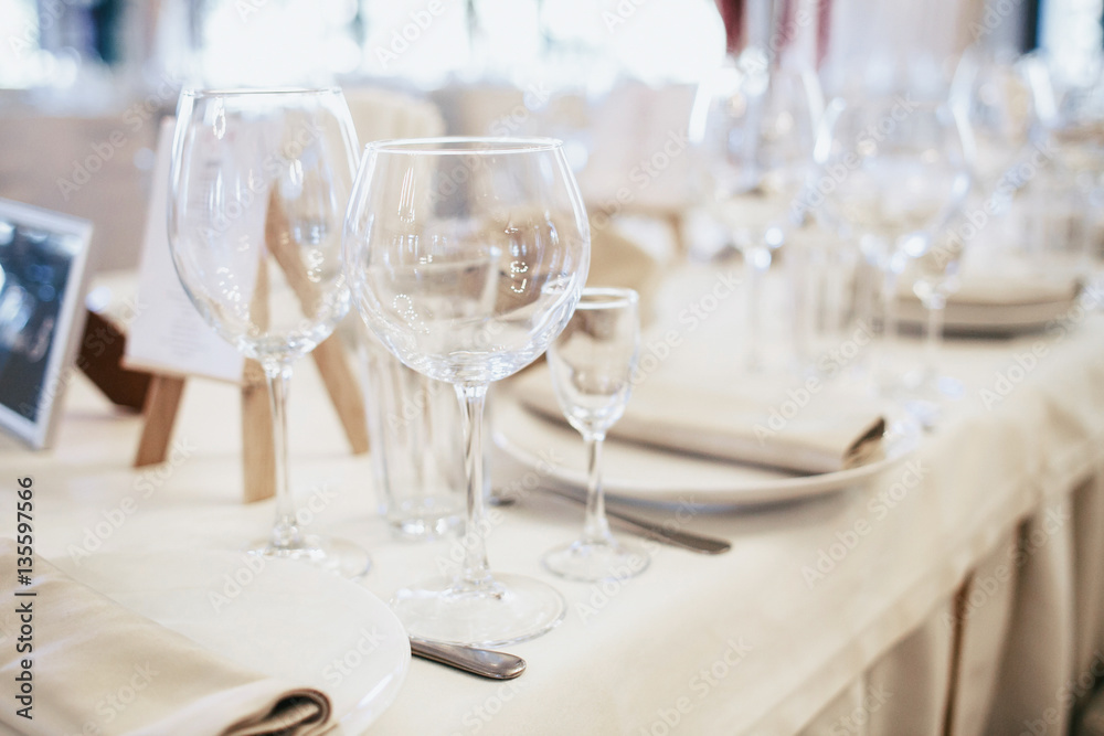 Sparkling glasses for wine and champagne stand between dinner pl Sparkling glasses for wine and champagne stand between dinner pl