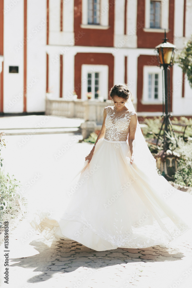 Stunning young bride whirls on path to red house Stunning young bride whirls on path to red house