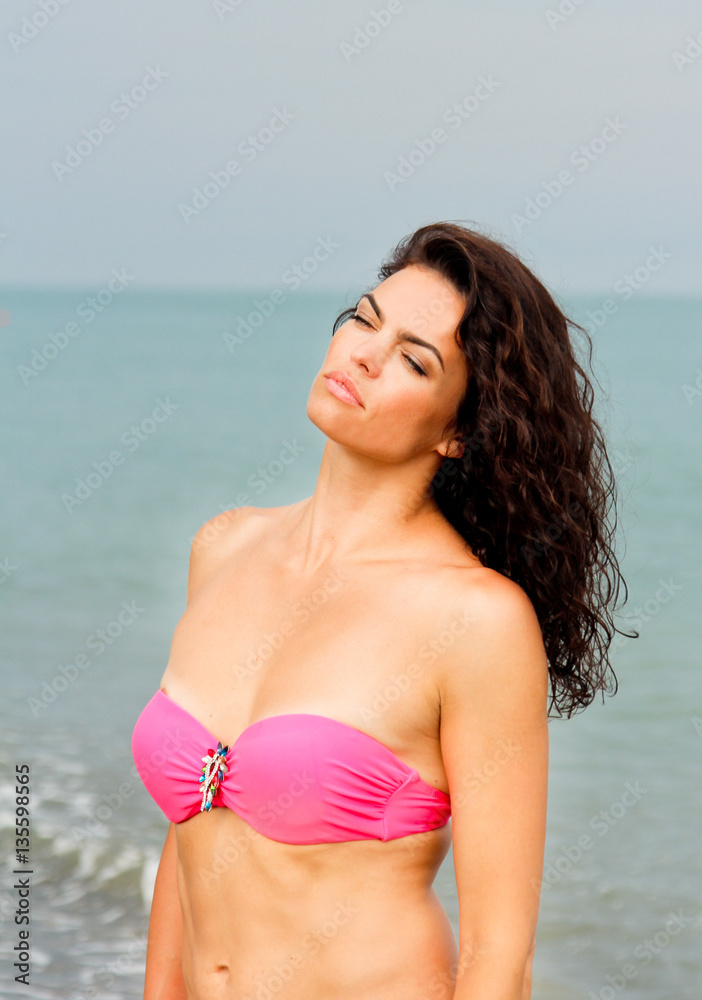 Portrait of beautiful woman in pink bikini on sea background. Woman resting in Batumi, Georgia