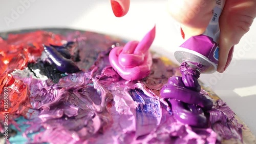 artist squeezes from the tube to the palette purple oily paint , 4k