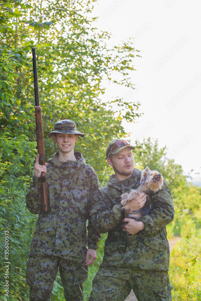 Hunters in camouflage and a gun