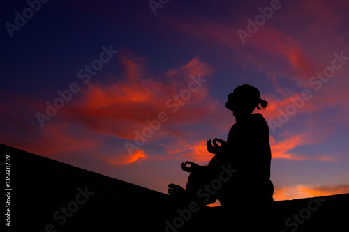 Yoga meditation by man silhouette. Purple sunset sky background. Free space for text.