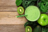 Green smoothie above view with kale, avocado, spinach, apple and kiwi against a rustic wooden background