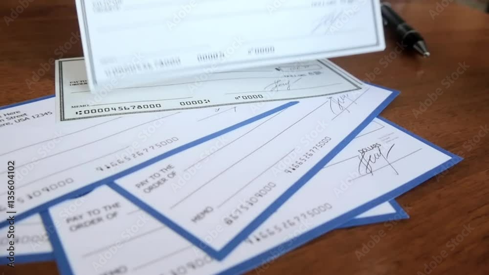 Close-up of human hand filling check. Check was designed by me, it is fake. The name signature etc are all fake. Close-up of human hand filling check. Check was designed by me, it is fake. The name signature etc are all fake.