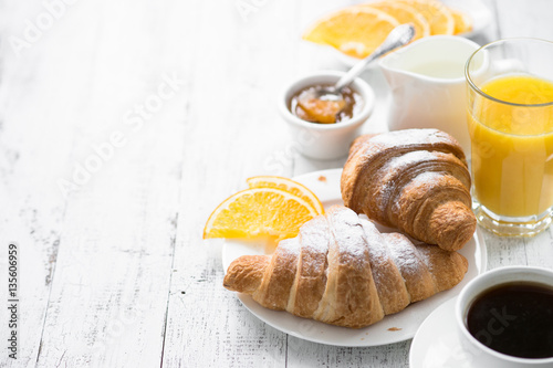 Croissant jam coffee orange juice at white wooden table. breakfast photo