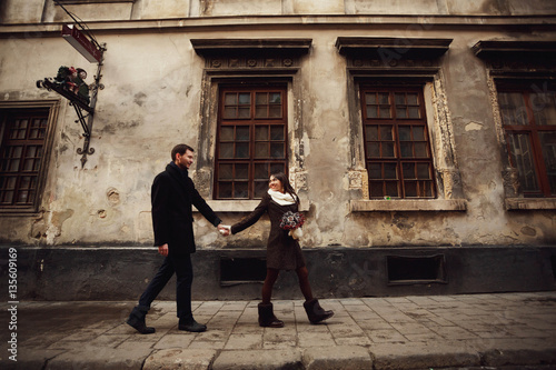 young man and woman walks near old building