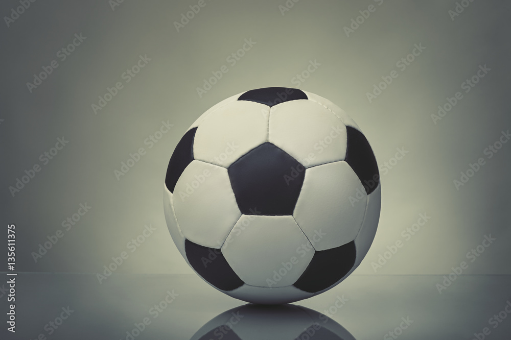soccer ball with reflection on a table on a gray background soccer ball with reflection on a table on a gray background