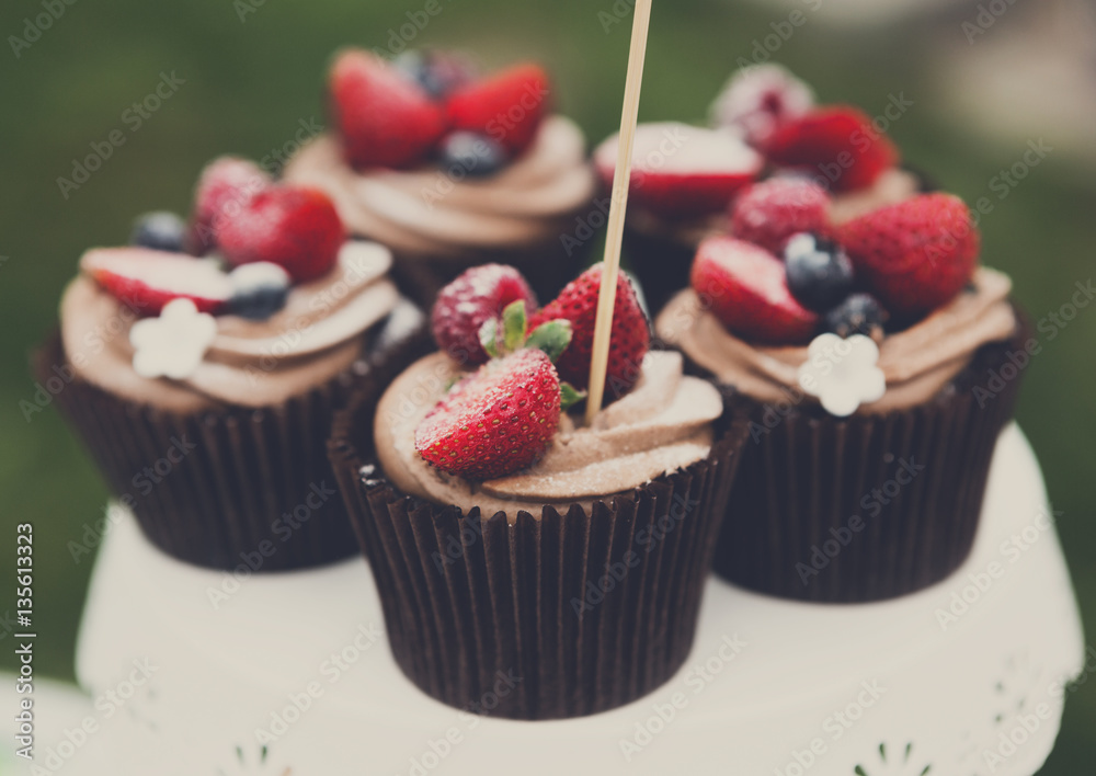 Beautiful cupcakes with berries closeup on banquet table. Beautiful cupcakes with berries closeup on banquet table.
