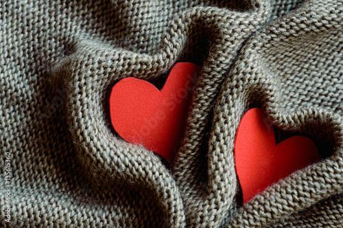 two red hearts wrapped in knitted fabric