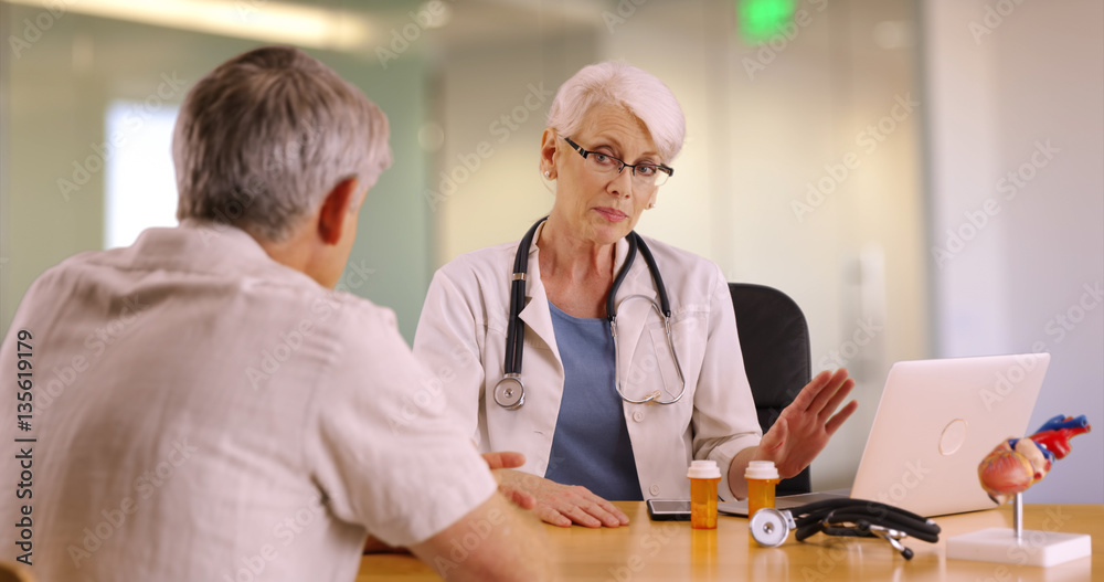 Confident Senior doctor talking with elderly man in the office Confident Senior doctor talking with elderly man in the office