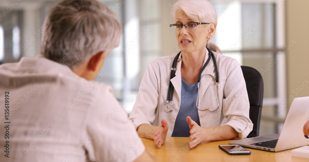 Confident doctor discussing health concerns with elderly man