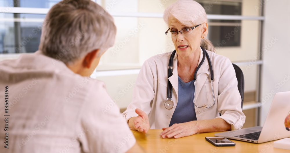 Senior woman doctor talking to elderly patient in the office Senior woman doctor talking to elderly patient in the office