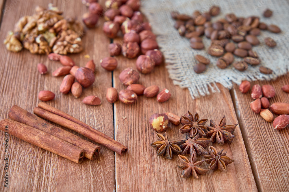 Cinnamon sticks, anise, coffee beans and nuts on a wooden background Cinnamon sticks, anise, coffee beans and nuts on a wooden background