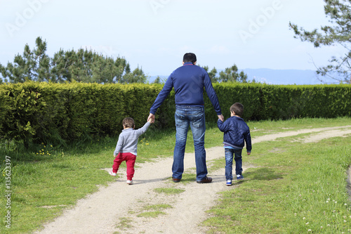 father and children walking in a path