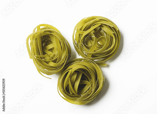 Res rolls of vegetable spaghetti on white background. Italian pasta. Horizontal shoot.