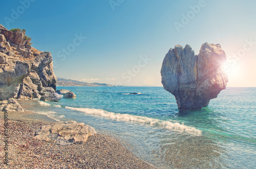 heart shaped rock on beach on sunny summer day
