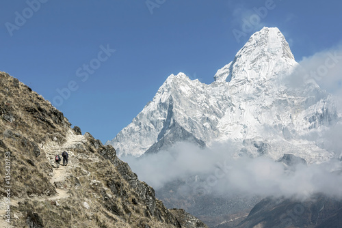 Tourists on the trail near Dingboche with Ama Dablam (6814 m) in the background - Everest region, Nepal photo