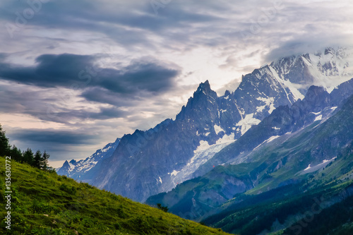 Sunset lights the sky over tall jagged mountains in the Italian alps near the Refuge Walter-Bonatti.